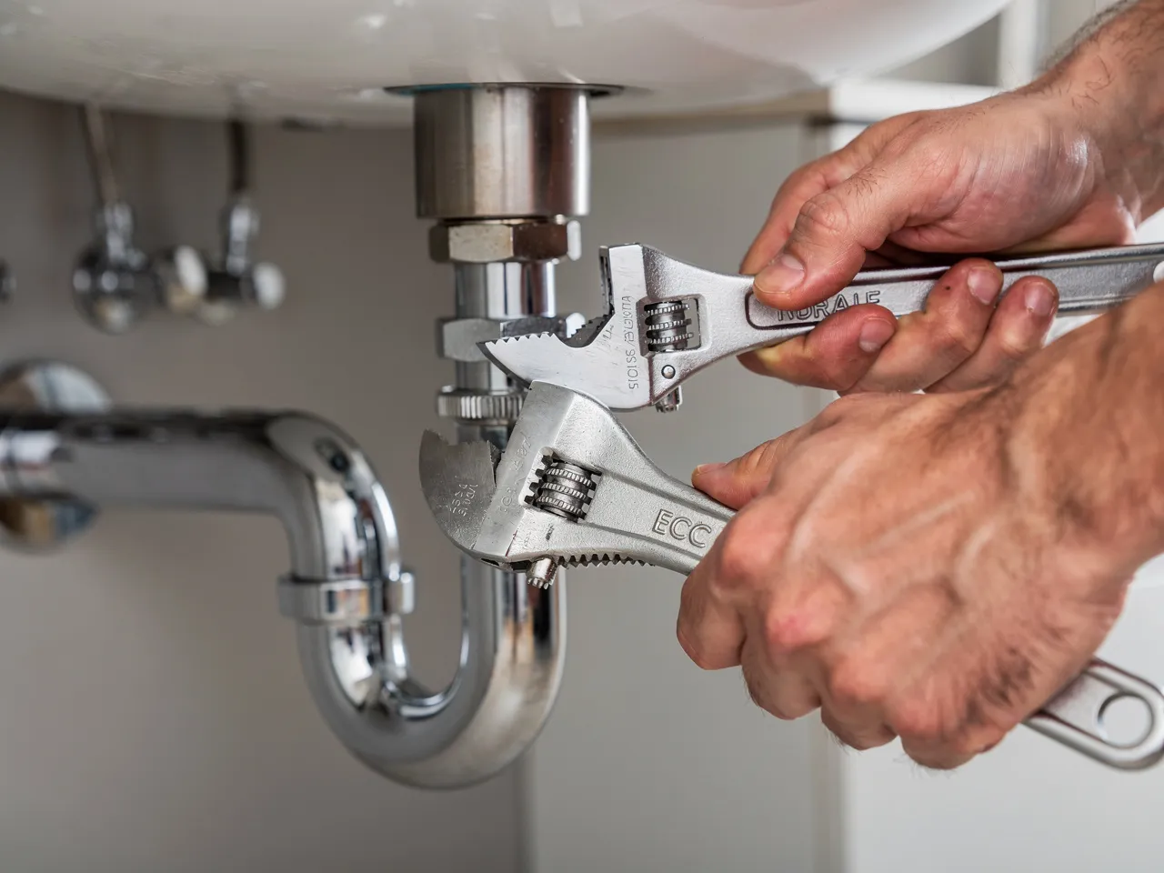 Skilled hands connecting plumbing pipes